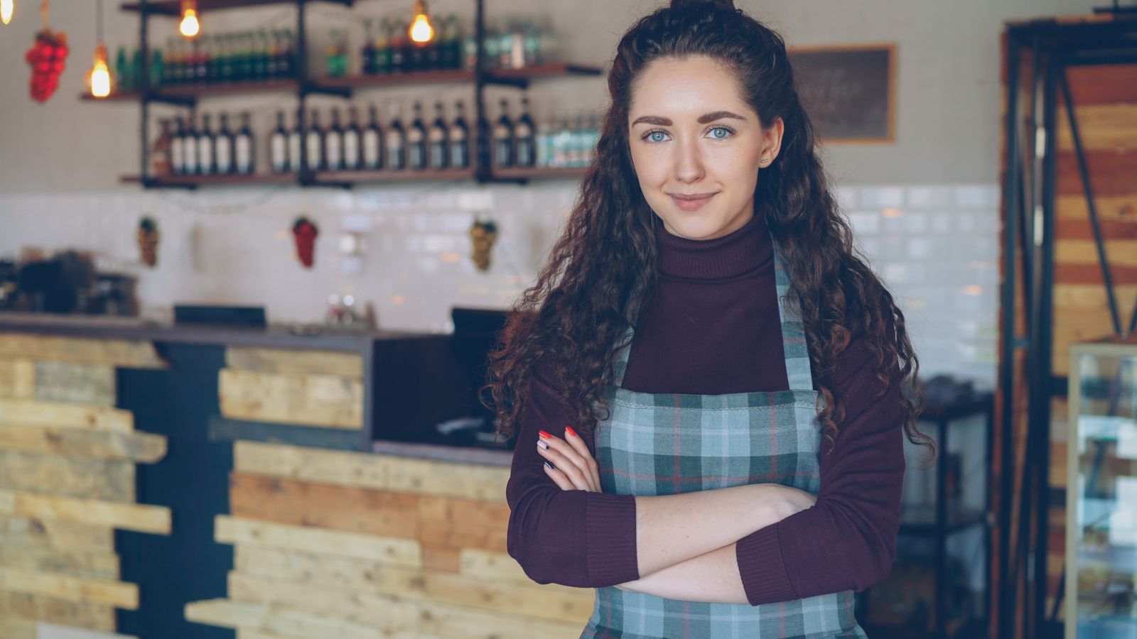 Small business owner standing behind the counter of a local shop